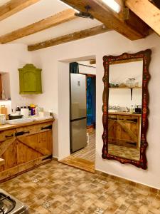 uma cozinha com armários de madeira e um espelho na parede em Hacienda Verde em Szentes