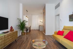 ein Wohnzimmer mit einem gelben Sofa und einem Tisch in der Unterkunft Casa Brezi in Palermo