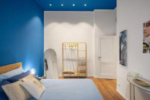 Schlafzimmer mit blauen Wänden, einem Bett und einem Spiegel in der Unterkunft Casa Brezi in Palermo