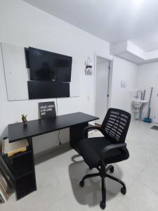 einen schwarzen Schreibtisch und einen Stuhl in einem Zimmer in der Unterkunft Apartamento Metrô Giovanni Gronchi - Expo Transamérica - Vibra São Paulo - Autódromo in São Paulo
