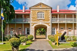 - un grand bâtiment en briques avec une arche devant dans l'établissement Rafeen villa- Historic villa with pool, à Bridgetown