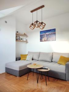 a living room with a couch and a table at Apartman NS Dan FREE PARKING in Novi Sad