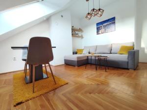 a living room with a couch and a chair at Apartman NS Dan FREE PARKING in Novi Sad