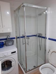 W łazience znajduje się kabina prysznicowa i pralka. w obiekcie Vivienda Vacacional Maga w Corralejo