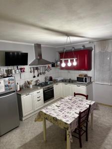 een keuken met een tafel en rode kasten bij Casa Il Gallo in Castellina Marittima