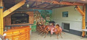 een eetkamer met een tafel en stoelen en een muurschildering bij Vikendica Lukavac in Lukavac