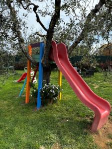 een rode glijbaan aan een boom in een park bij Casa Il Gallo in Castellina Marittima