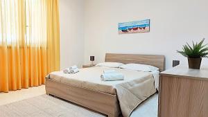 ein Schlafzimmer mit einem Bett in einem Zimmer in der Unterkunft Appartamenti in Villa Polimnia in Fontane Bianche