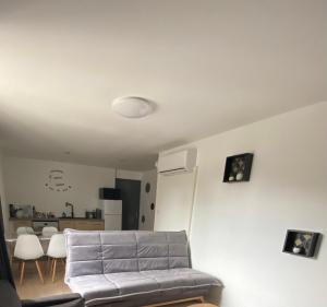 uma sala de estar com um sofá cinzento e uma mesa em Bel Appartement 1er étage t2 4 pers avec cour les cocons de Madenn em Lamballe