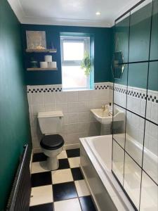a bathroom with a toilet and a tub and a sink at Dragon Parade Apartment in Harrogate