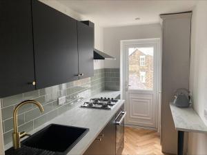 a kitchen with a sink and a stove top oven at Dragon Parade Apartment in Harrogate