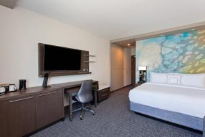 a hotel room with a bed and a desk and a tv at Courtyard by Marriott San Diego El Cajon in El Cajon