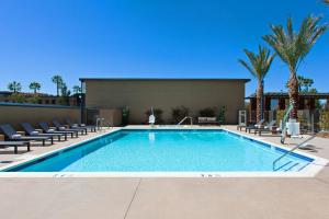 une grande piscine avec des chaises et un bâtiment dans l'établissement Courtyard by Marriott San Diego El Cajon, à El Cajon
