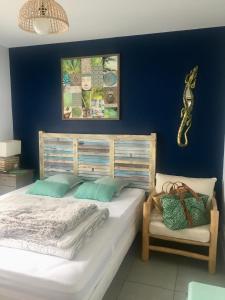 een slaapkamer met een groot bed en een blauwe muur bij "Les 2 Pins" Villas 4 chambres 10-12 couchages in Lacanau