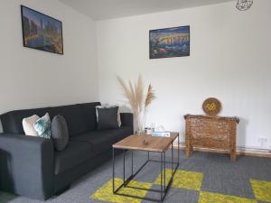 sala de estar con sofá y mesa en Casuta din Gradina, en Horezu