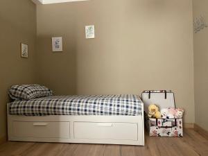 1 dormitorio con 1 cama con manta a cuadros y 1 maleta en Casa di Lucy Umbria, en Foligno