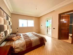 a bedroom with a bed and a large window at Villa Belle Plage Dar Bouazza in Casablanca