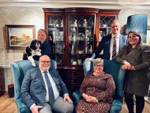 a group of people sitting in chairs with a dog at Boutique Hotel De Castillion - Small elegant family hotel in Bruges