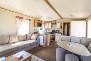 sala de estar con sofá y mesa en Brilliant 8 Berth Caravan Near Walton-on-the-naze In Essex - 17023nm, en Walton-on-the-Naze