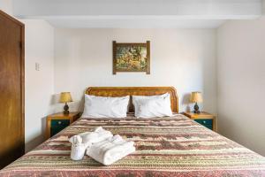 Una habitación de hotel con una cama con toallas. en 02- American Black Bear At Village Suites Inn en Big Bear Lake