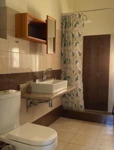 a bathroom with a sink and a toilet and a shower at Helen's cozy studio (close to the airport) in Koropíon
