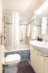 Un baño con inodoro, lavabo y bañera. en Cozy central apartment a few steps from the beach, en Hersonissos