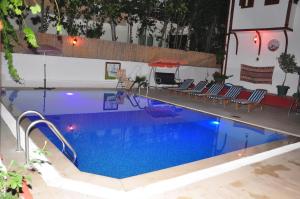 een groot zwembad met stoelen en blauw water bij Kaliptus Hotel in Kemer