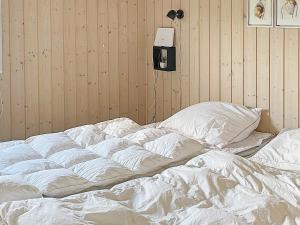 1 cama no hecha en una habitación con pared en Holiday home Sydals XL, en Neder Lysabild