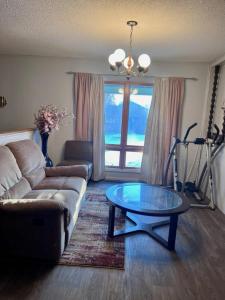 een woonkamer met een bank en een glazen tafel bij Shaligohomes @ 4425 E 6th Ave in Anchorage