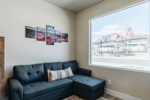 a living room with a blue couch and a window at Grand Canyon-4bed,3bath,hot tub in Hildale