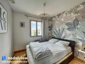 um quarto com uma cama com uma parede floral em Villa Azurella em Villeneuve-Loubet