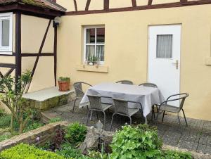 a table and chairs sitting outside of a house at Historisches Fachwerkhaus in Königsberg in Bayern