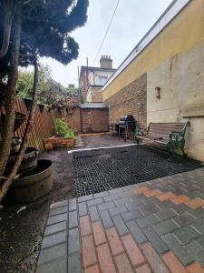 a patio with a bench next to a building at Maidstone castle 3bedroom free sports channels, parking in Kent