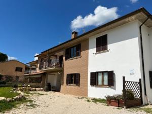 uma grande casa branca e castanha com um quintal em La Casa di Demetra. Un Paradiso tra gli Olivi. em Montecchio