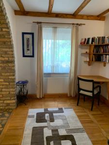 ein Wohnzimmer mit einem Tisch und einem Fenster in der Unterkunft Kuća Miris severa in Šupljak