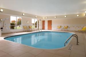 a pool in a hotel room with chairs and tables at Fairfield Inn & Suites Youngstown Boardman Poland in Poland