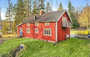 una casa roja sentada en la cima de un campo de hierba en Amazing Home In ml With Wifi, en Åmål