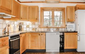 - une cuisine avec des placards en bois et un réfrigérateur blanc dans l'établissement Amazing Home In ml With Wifi, à Åmål