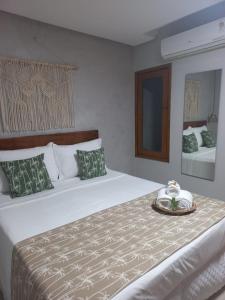 Un dormitorio con una cama grande y una bandeja. en Meu Dengo Pousada, en Morro de São Paulo