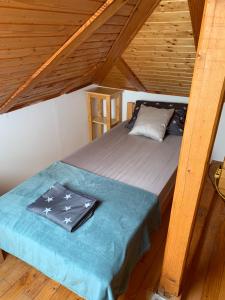 a bed in a room with a wooden ceiling at Kuća Miris severa in Šupljak