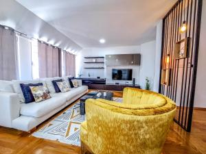 uma sala de estar com um sofá branco e duas cadeiras em Lofty em Brčko