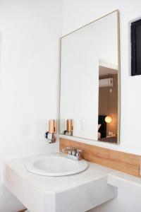 een badkamer met een witte wastafel en een spiegel bij Acacia Hotel in Tuxtla Gutiérrez
