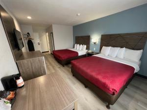 a hotel room with two beds and a red couch at Quality Inn Tracy I-205 in Tracy