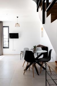 a dining room with white walls and a table and chairs at Pagani Blue - Luxury Maisonette B3 in Kalamata
