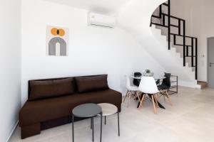 a living room with a couch and a table and chairs at Pagani Blue - Luxury Maisonette B3 in Kalamata