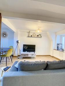 a living room with a blue couch and a tv at Charmant triplex centre-ville de Chantilly in Chantilly