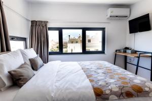a bedroom with a large white bed with a window at Pagani Blue - Luxury Maisonette B3 in Kalamata