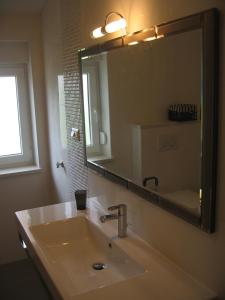 a bathroom with a sink and a large mirror at Apartments Car in Šilo