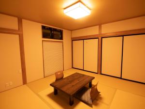 ein Raum mit einem Holztisch und einem Stuhl in der Unterkunft Kyufukujyuin Takei Ryokan in Nagano