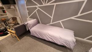 ein Schlafzimmer mit einem Bett mit einer geometrischen Wand in der Unterkunft Rear of Levett Gardens in Seven Kings